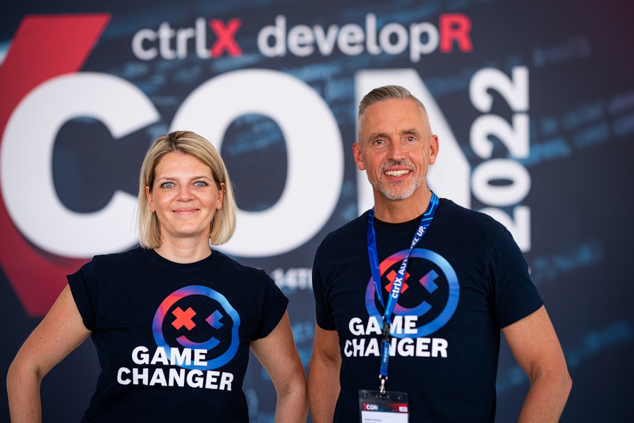 Moderator Jasmin Heim, Director Marketing, and Steffen Winkler, Chief Security Officer of Bosch Rexroth, in front of a poster of the ctrlX developR Conference