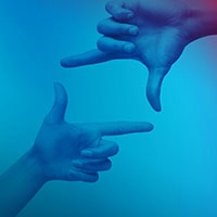 Blau gefärbtes Bild, zwei Hände beschreiben ein Rechteck