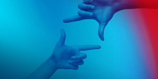 Zwei Hände bilden jeweils mit Daumen und Zeigefinger ein symbolisiertes Quadrat.