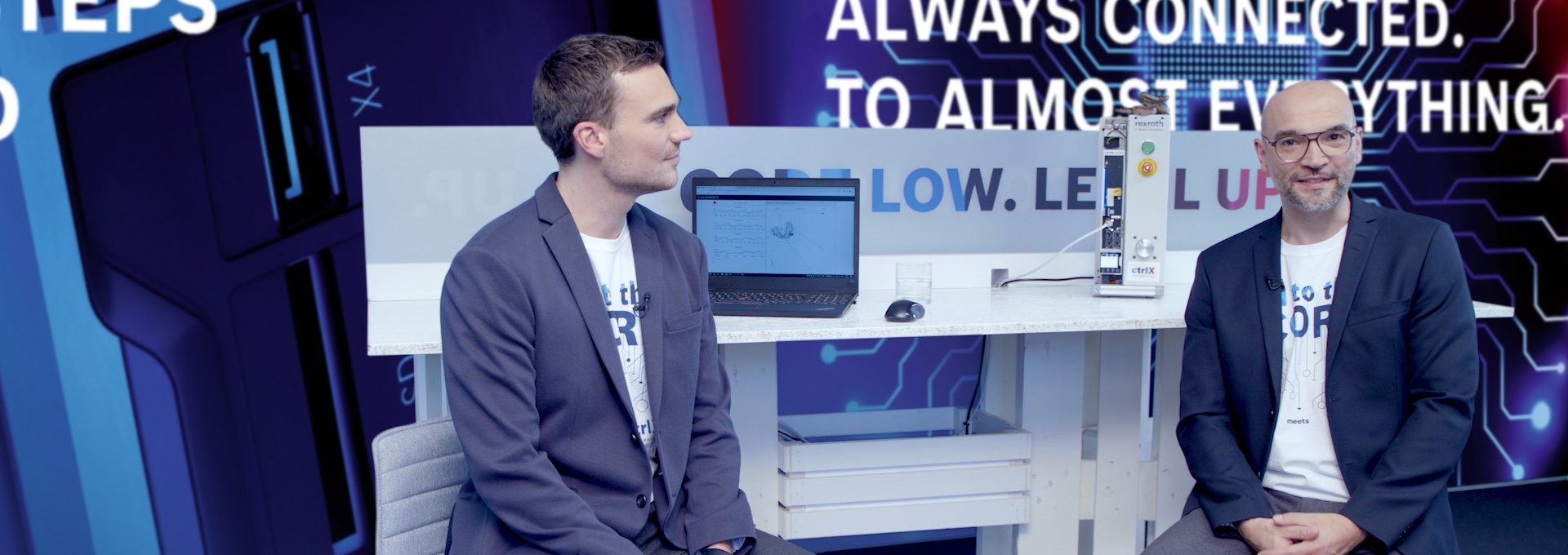 Gospodarz Christian Zentraf i jego gość Johannes Albrecht siedzą przy stole i rozmawiają o języku programowania Python w połączeniu z rozwiązaniem automatyzacji ctrlX AUTOMATION.