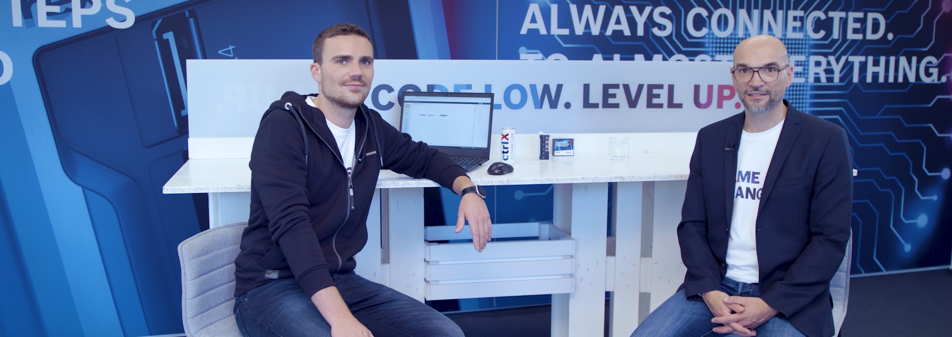 Gastgeber Christian Zentraf und sein Gast Johannes Albrecht sitzen an einem Tisch und sprechen über standartisierte Schnittstellen, wie das REST-Interface, der Automatisierungslösung ctrlX AUTOMATION
