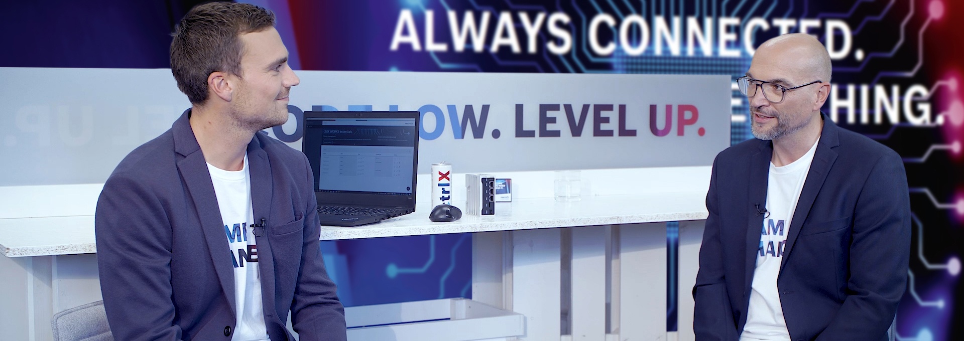 Gospodarz Christian Zentraf i jego gość Johannes Albrecht siedzą przy stole i rozmawiają o ctrlX Data Layer, centralnym systemie nev rozwiązania automatyzacji ctrlX AUTOMATION.
