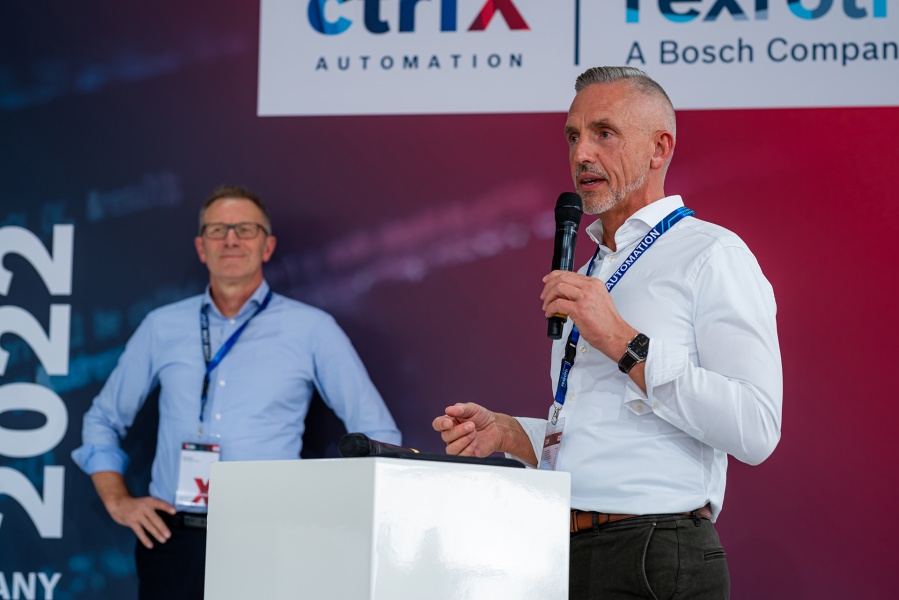 Speaker und Chief Security Officer der Bosch Rexroth Business Unit Automation and Electrification Steffen Winkler auf der Bühne mit Jury Mitglied Rolf Najork im Hintergrund