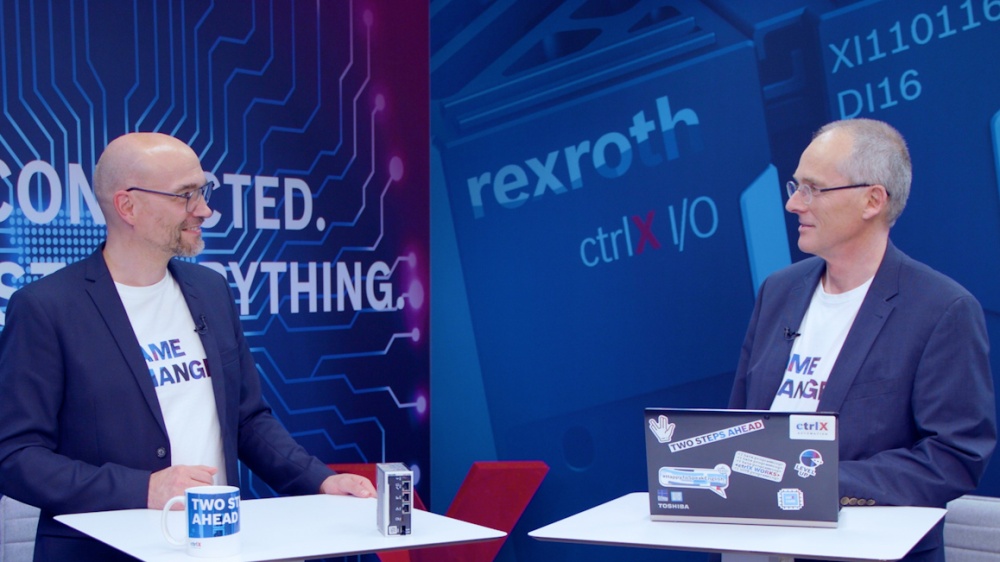 Host Christian Zentraf and his guest Thomas Fey stand at meeting tables and talk about web-based HMI applications for operation and visualization, the automation solution ctrlX AUTOMATION