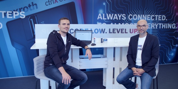 Gospodarz Christian Zentraf i jego gość Johannes Albrecht siedzą przy stole i rozmawiają o standardowych interfejsach, takich jak interfejs REST, rozwiązania automatyzacji ctrlX AUTOMATION.