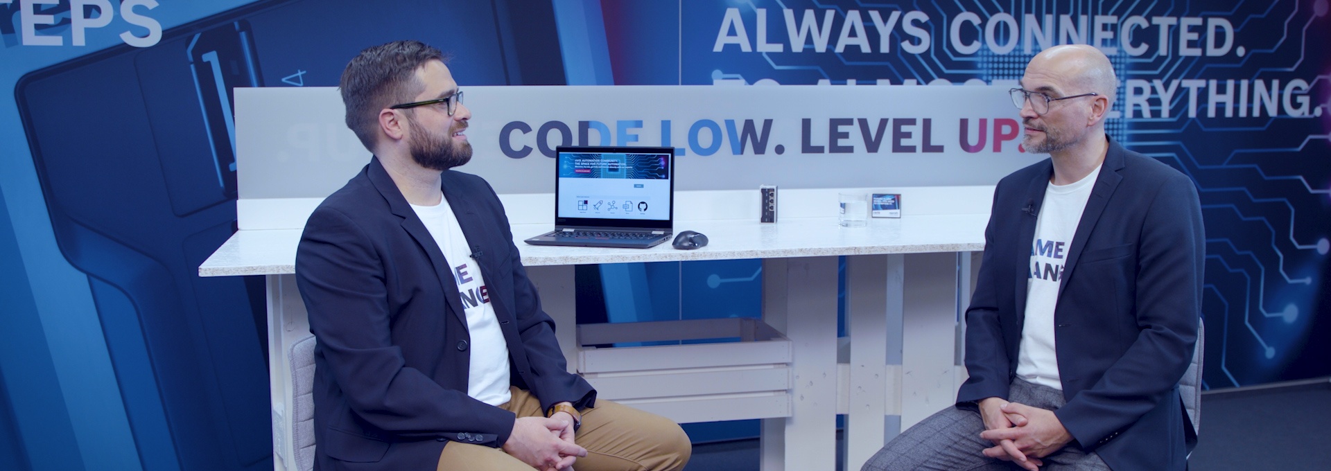 Gospodarz Christian Zentraf i jego gość Pedro Reboredo siedzą przy stole i rozmawiają o ctrlX AUTOMATION Community, platformie wymiany dla deweloperów, rozwiązaniu automatyzacji ctrlX AUTOMATION