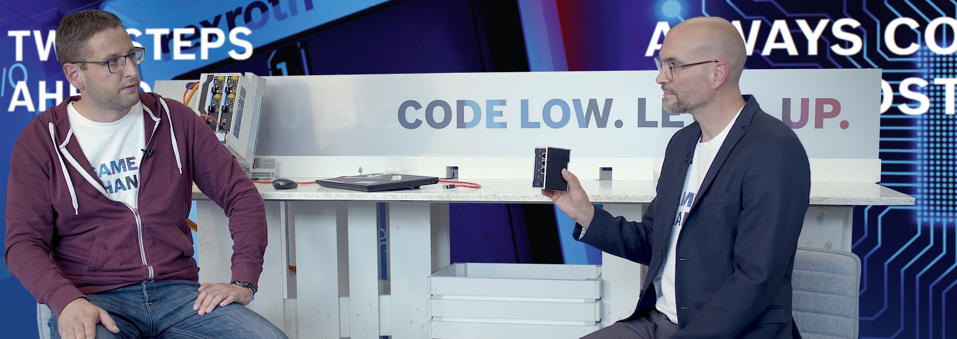 Gospodarz Christian Zentraf i jego gość Kai Müller siedzą przy stole i rozmawiają o uruchomieniu sterownika ctrlX CORE