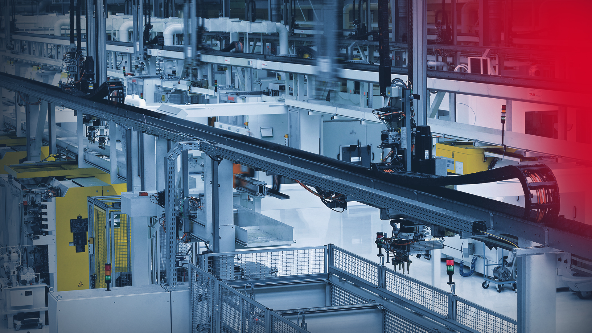Hala fabryczna z robotami bramowymi, które zaopatrują centra obróbcze w materiał