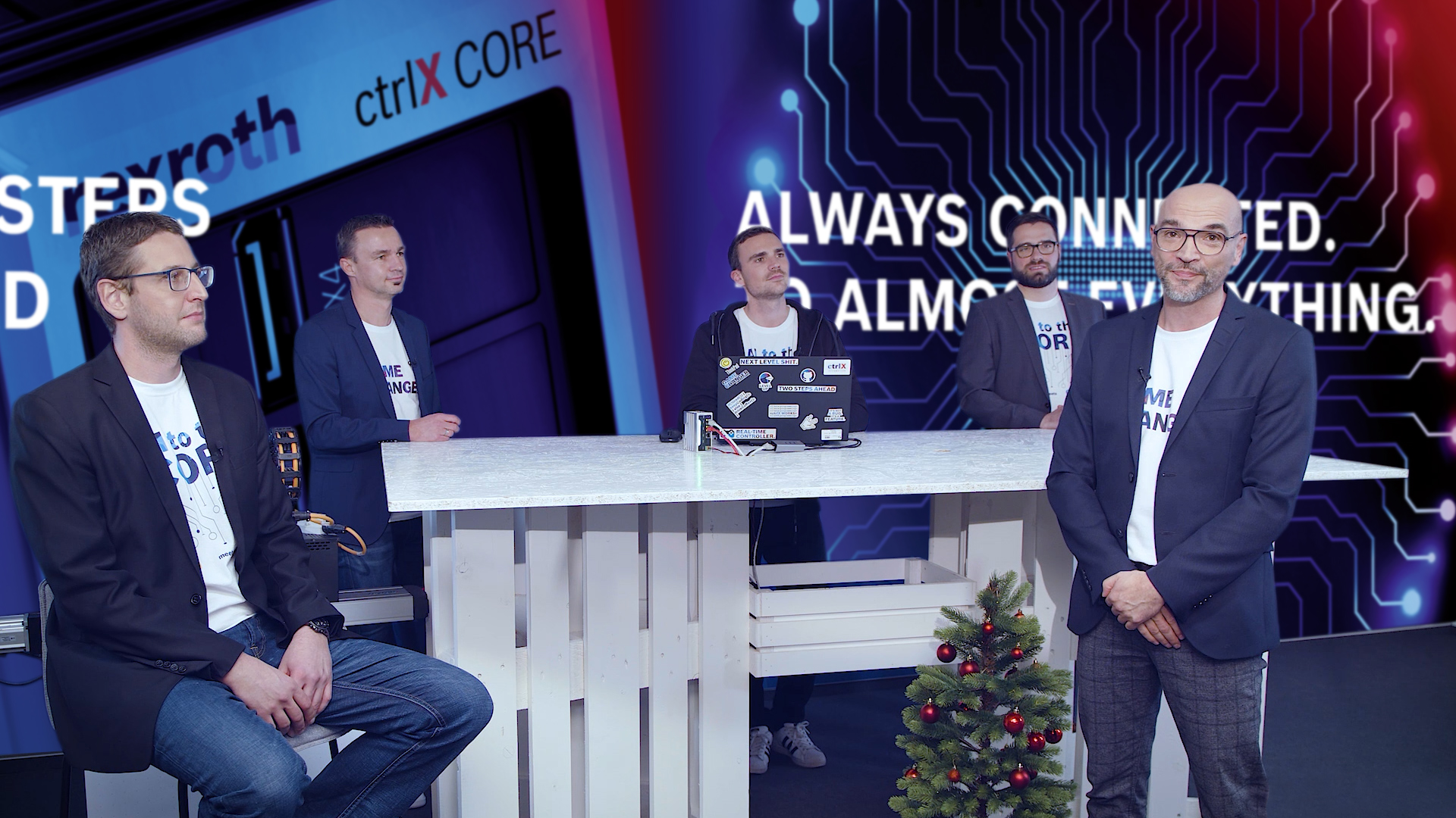 Host Christian Zentraf and his guests Johannes Albrecht, Pedro Reboredo, Holger Schnabel and Kai Müller sit at a table and talk about graphical programming with Blockly of the automation solution ctrlX AUTOMATION